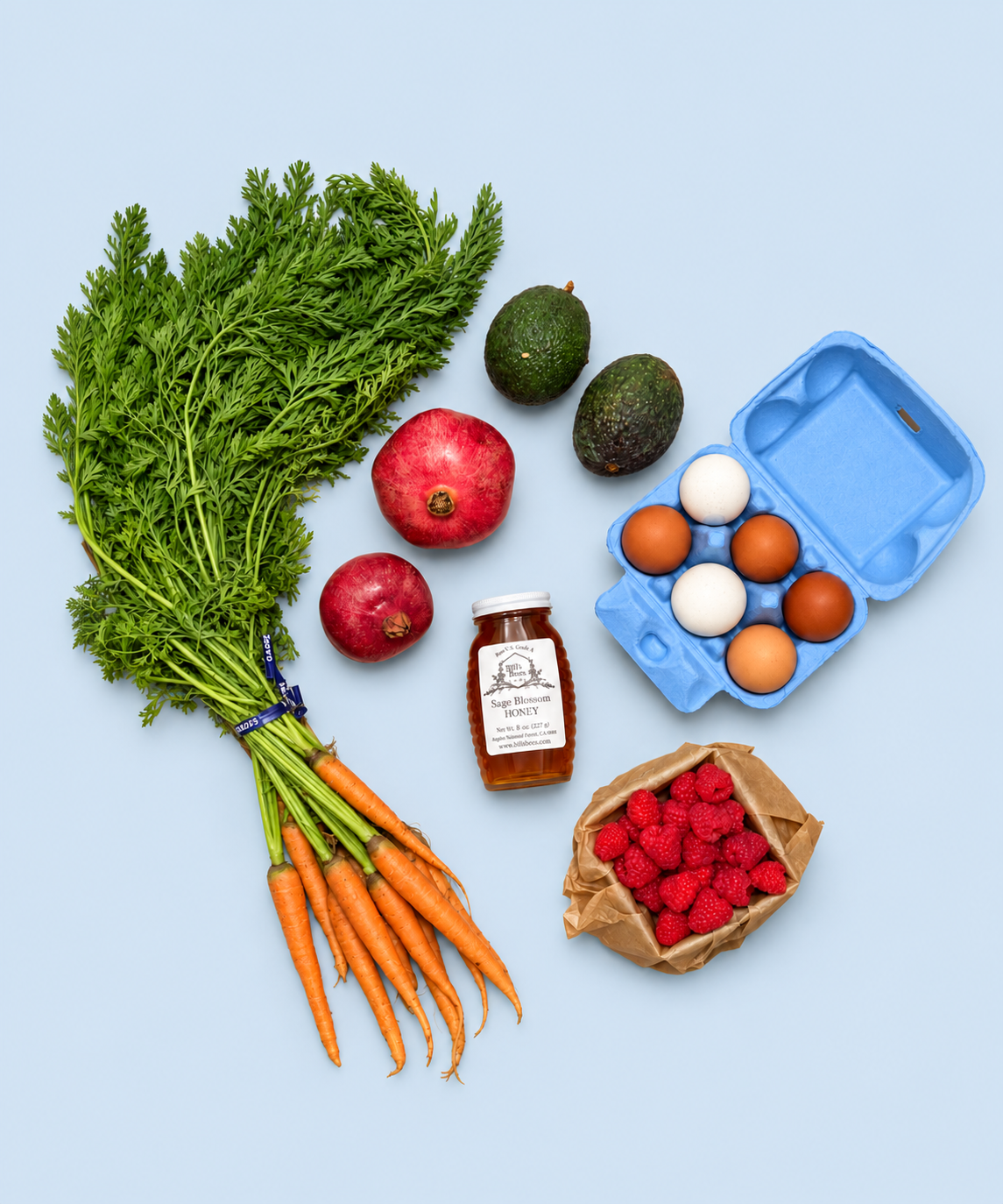 Mini Market Box contents: Bill’s Bees raw honey, a half dozen pasture-raised heirloom eggs, bunched carrots, avocados, pomegranates and raspberries