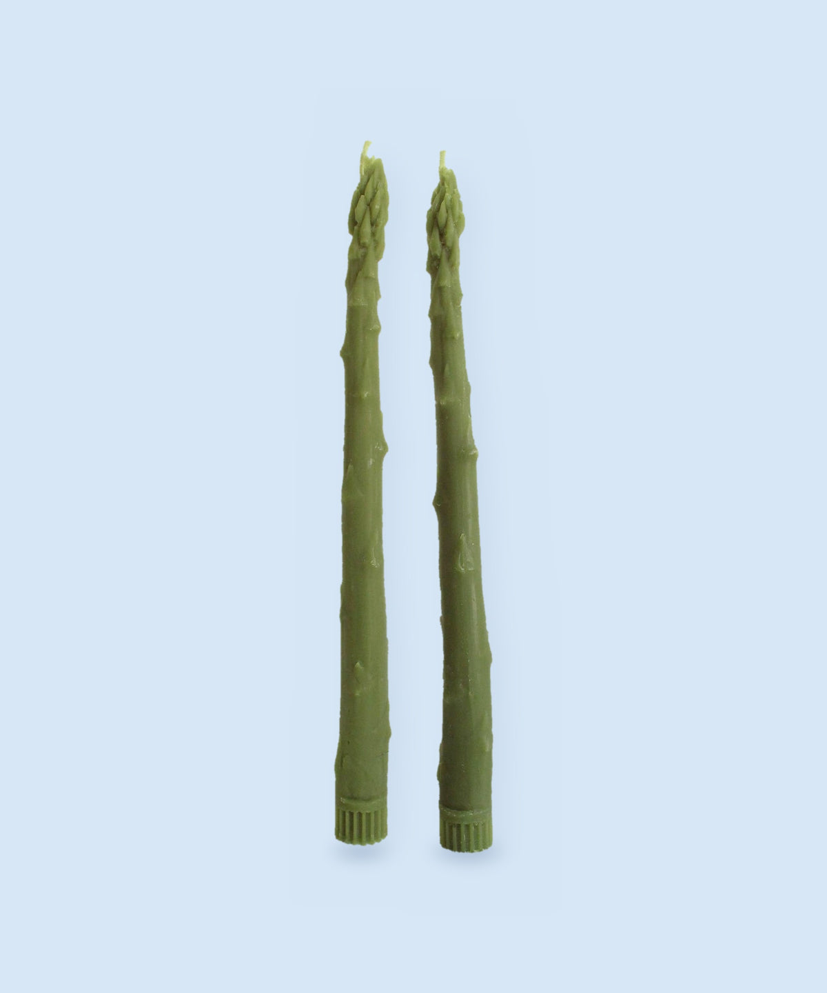 Asparagus beeswax taper candles, set of 2, handmade in Los Angeles, on a pale blue background
