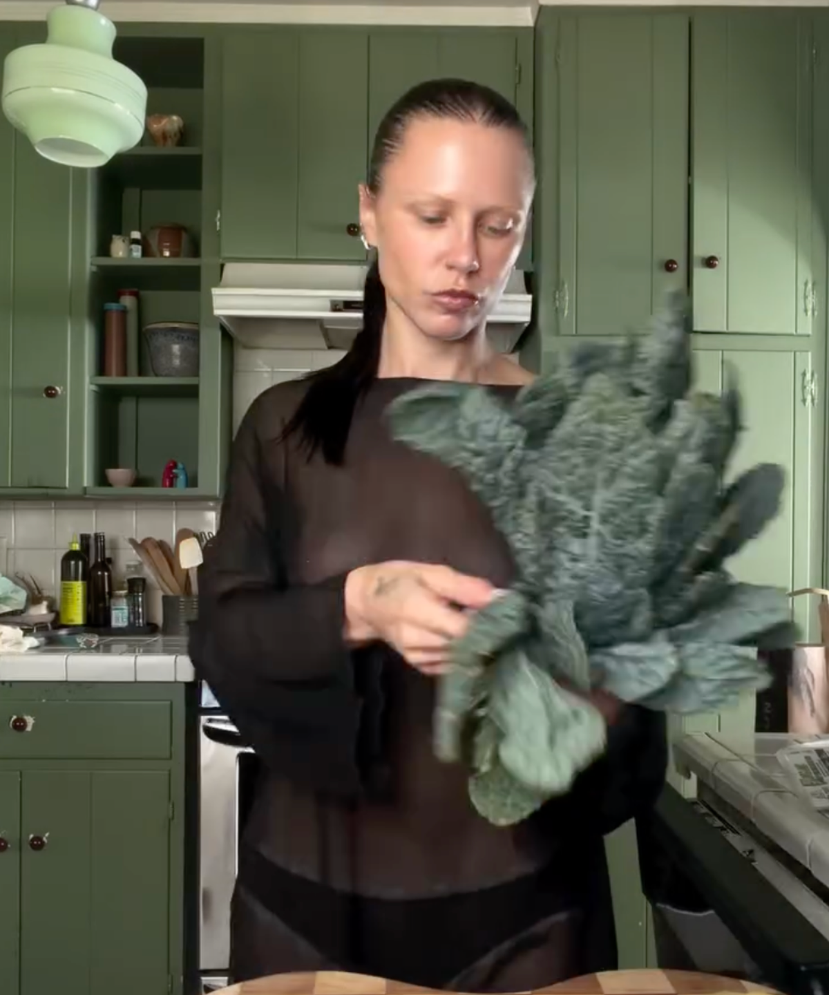 Courtney Trop of @alwaysjudging in her kitchen holding dino kale from The Sexy Chef Box by Market Mama, a limited-edition seasonal produce box delivered in Los Angeles