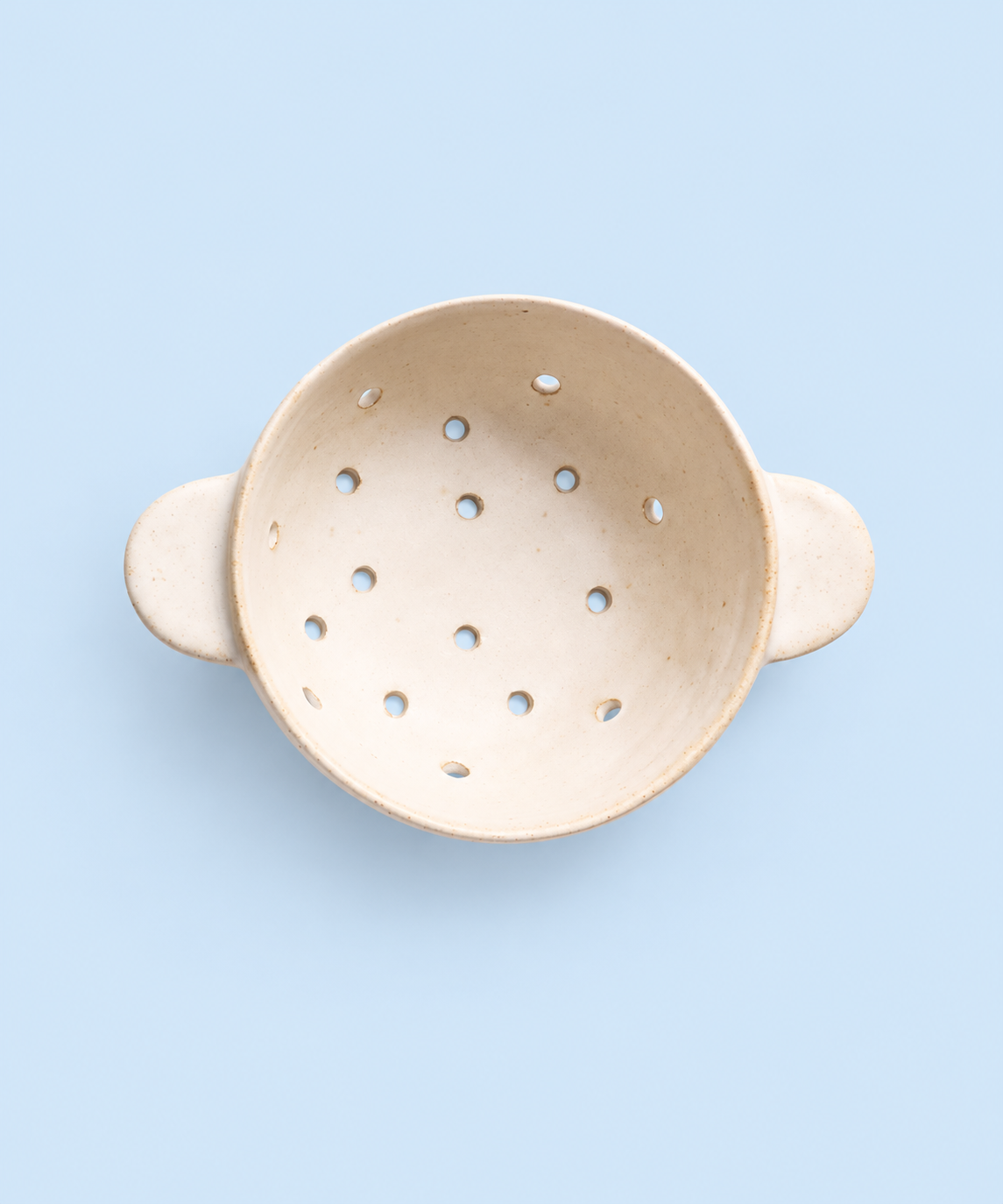 Beige speckled ceramic berry bowl colander with drainage holes and handles, handmade stoneware