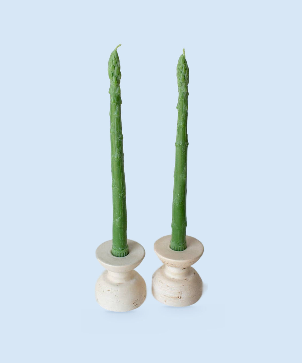 Two asparagus beeswax taper candles in cream candle holders, handmade in Los Angeles